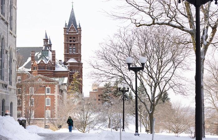 Student walking across campus in the winter